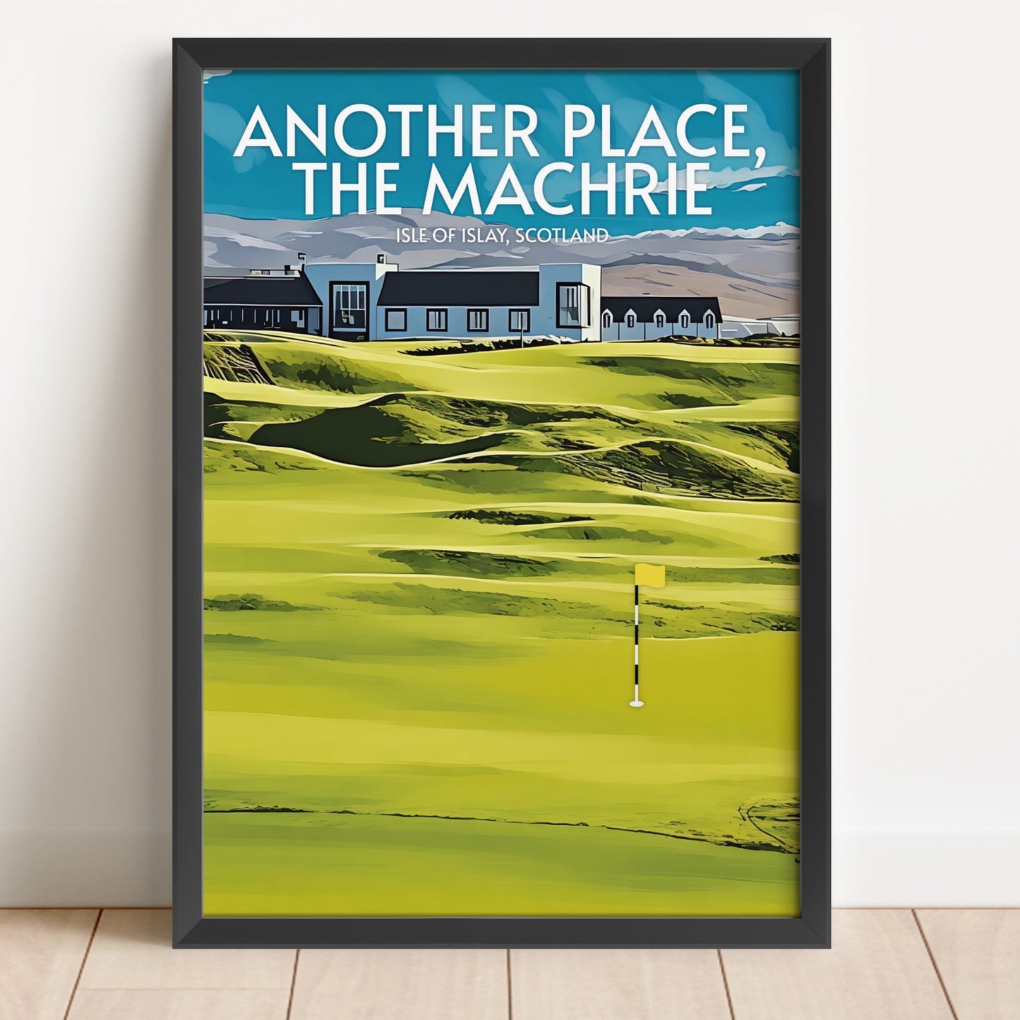 Framed poster of a golf course with text 'Another Place, The Machrie' on a white wall.