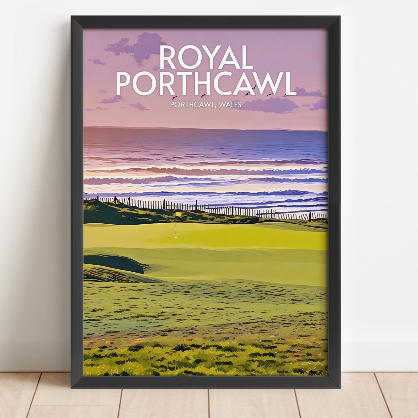 Framed artwork of a golf course with 'Royal Porthcawl' text on a white wall.